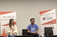 two people sitting on a stage at a startup event